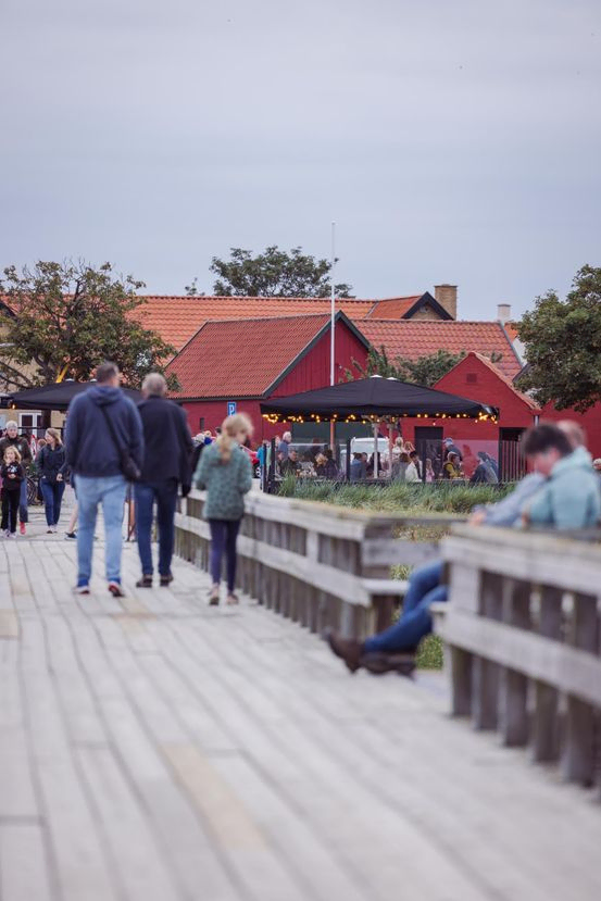 En af terrasserne ved Sørens Værtshus med udsigt til havet. Set fra broen som fører ud til fiskerlejet. Der er gyngestativ til børn.